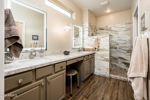 bathroom featuring vanity, wood-type flooring, and tiled shower