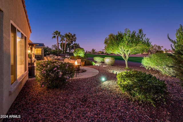 yard at dusk with a patio area