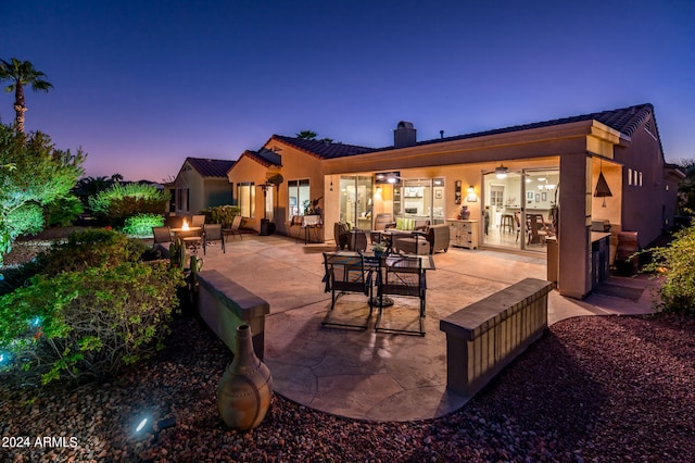 back house at dusk with a patio