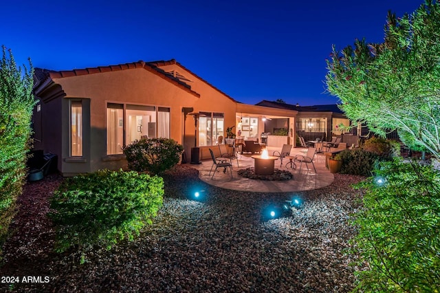 back house at twilight with a patio