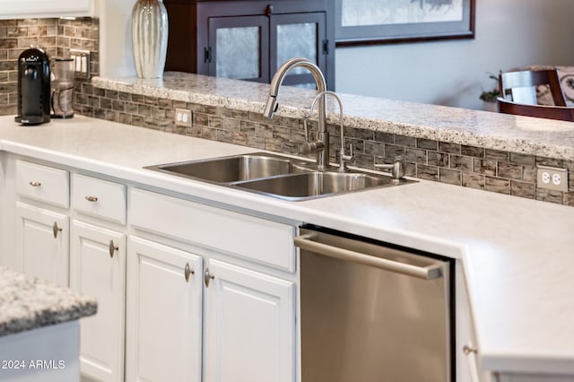 kitchen with white cabinetry, backsplash, sink, and stainless steel dishwasher