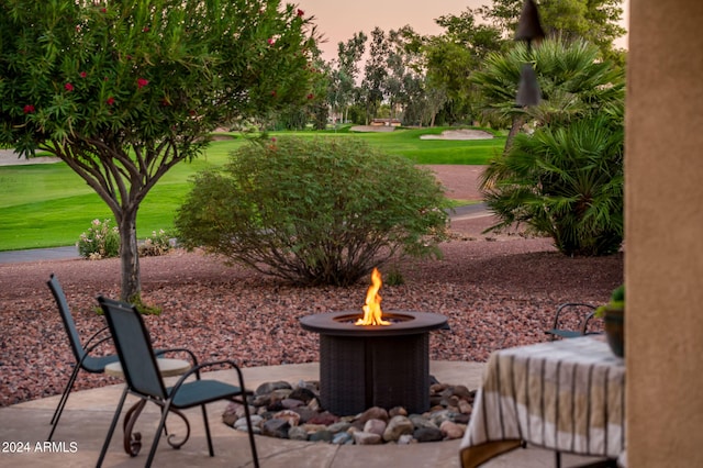 patio terrace at dusk with a lawn and a fire pit