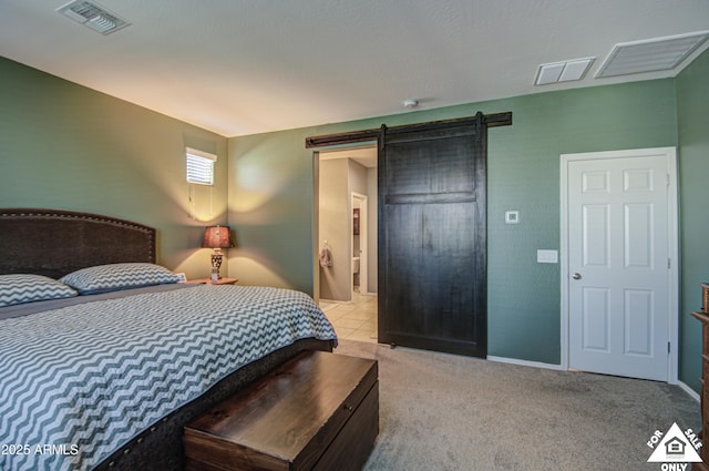 bedroom with light colored carpet and a barn door