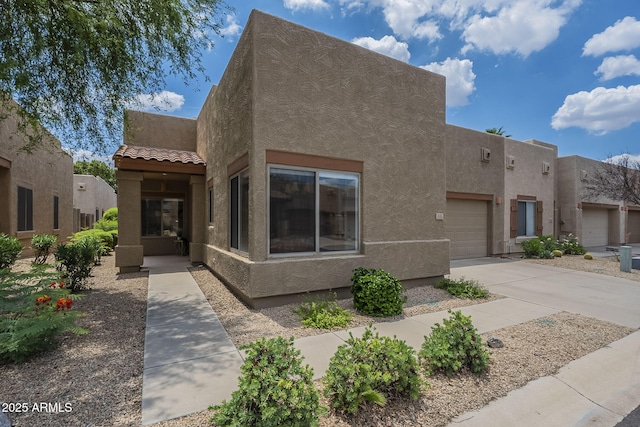1650 S Crismon Rd Unit 63, Mesa, AZ 85209 - pueblo-style home with stucco siding, driveway, a tiled roof, and an attached garage