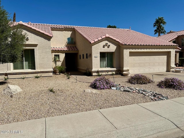 mediterranean / spanish home featuring concrete driveway, a tiled roof, a garage, and stucco siding