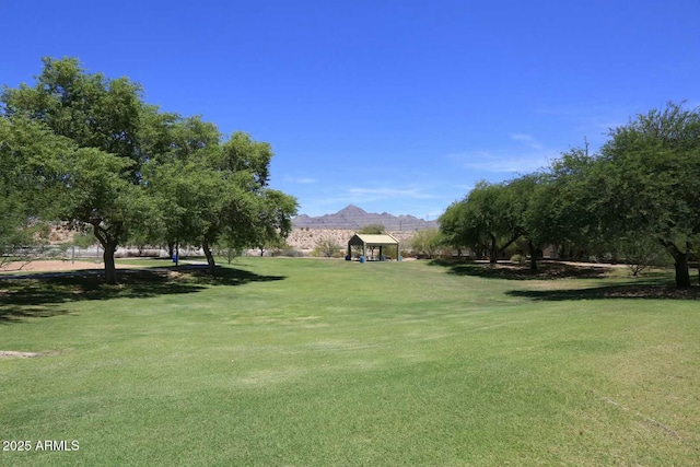 surrounding community with a gazebo, a mountain view, and a yard