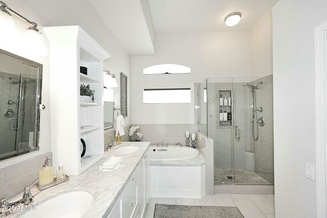 full bath featuring a sink, double vanity, a bath, and a shower stall