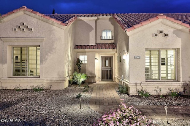 view of front of house featuring a tile roof and stucco siding