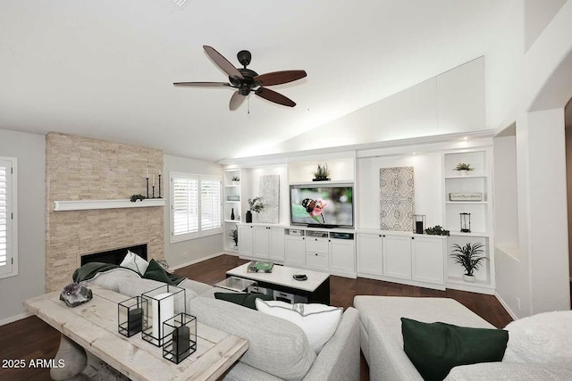 living area featuring built in features, a ceiling fan, a fireplace, dark wood-style flooring, and vaulted ceiling