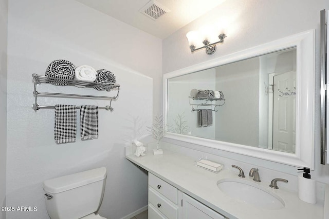 half bath featuring visible vents, toilet, and vanity