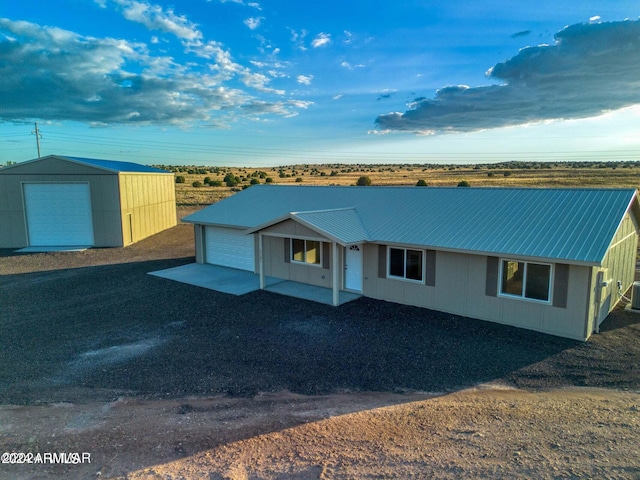 view of front of property featuring a garage and an outdoor structure