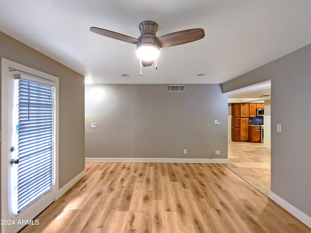 spare room featuring visible vents, baseboards, light wood-style floors, and a ceiling fan