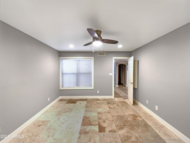 spare room with visible vents, a ceiling fan, recessed lighting, arched walkways, and baseboards