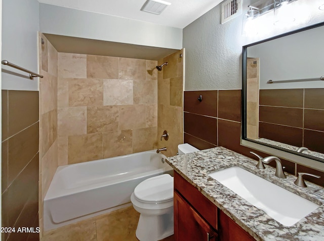 full bathroom featuring visible vents, toilet, tile walls, and shower / washtub combination