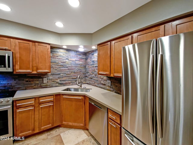 kitchen featuring brown cabinetry, a sink, light countertops, appliances with stainless steel finishes, and backsplash