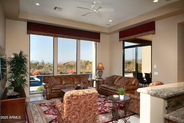 living room with ceiling fan and a wealth of natural light