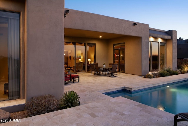 pool at dusk featuring a patio area