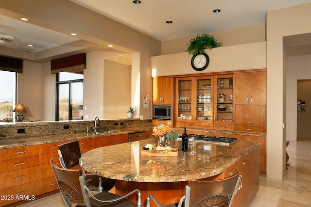 kitchen featuring a spacious island, appliances with stainless steel finishes, a kitchen breakfast bar, and sink