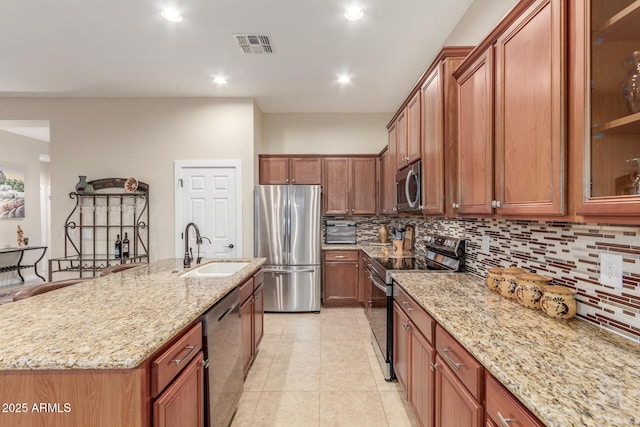 13102 S 177th Dr, Goodyear, AZ 85338 - kitchen featuring sink, light stone counters, tasteful backsplash, a center island with sink, and stainless steel appliances
