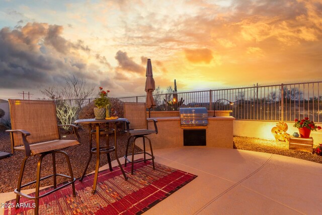 13102 S 177th Dr, Goodyear, AZ 85338 - patio terrace at dusk featuring area for grilling and exterior kitchen