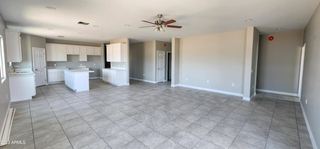 kitchen featuring a kitchen island, light tile flooring, ceiling fan, white cabinetry, and sink