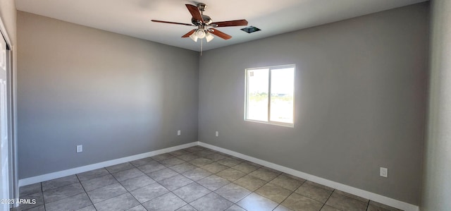 tiled spare room featuring ceiling fan