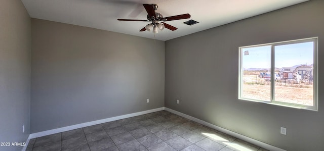 tiled spare room with ceiling fan