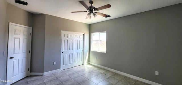 unfurnished bedroom with light tile flooring and ceiling fan