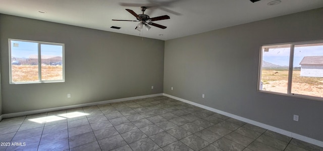 tiled spare room with ceiling fan and a wealth of natural light