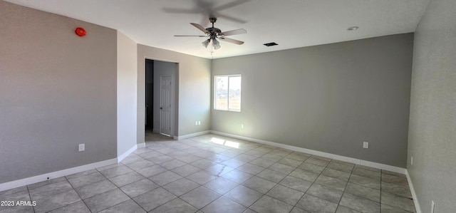 tiled spare room featuring ceiling fan