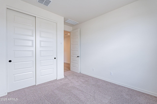 unfurnished bedroom featuring visible vents, baseboards, carpet flooring, and a closet