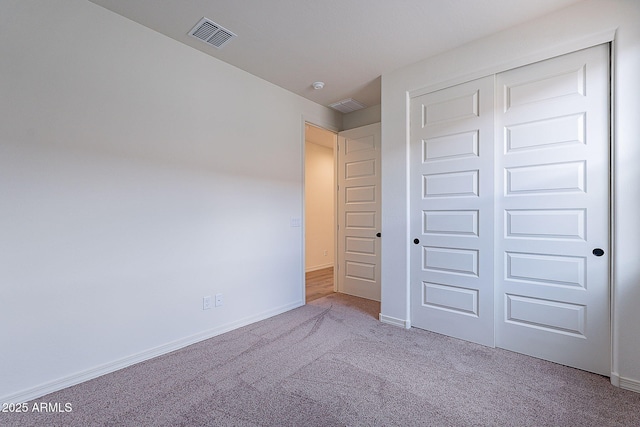 unfurnished bedroom with visible vents, baseboards, a closet, and carpet