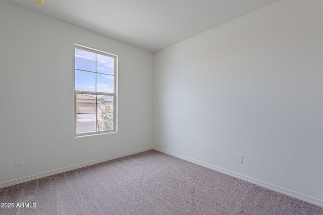 spare room featuring carpet flooring and baseboards