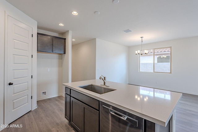 kitchen with stainless steel dishwasher, light wood-style flooring, visible vents, a sink, and light countertops
