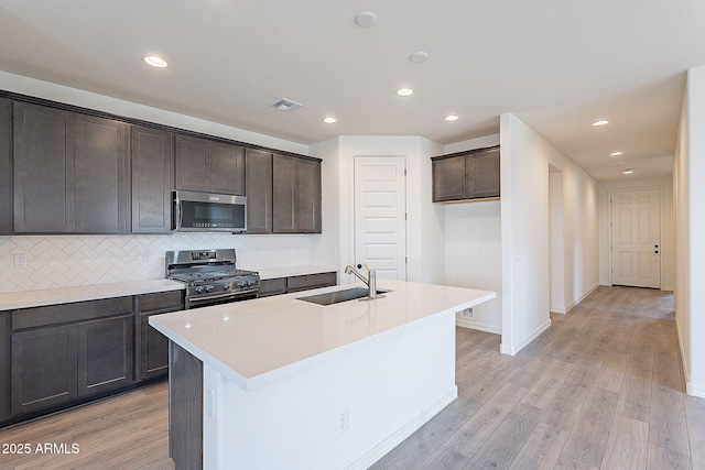 kitchen featuring a sink, visible vents, appliances with stainless steel finishes, and dark brown cabinetry