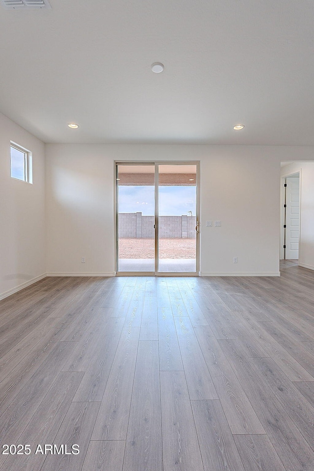 empty room with recessed lighting, light wood-style floors, baseboards, and visible vents