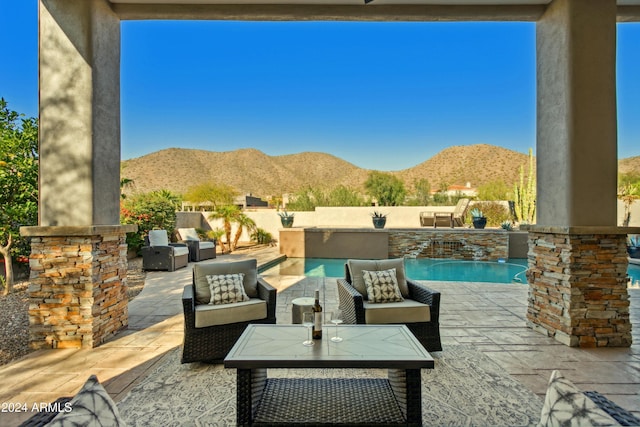 view of patio featuring a fenced in pool, a mountain view, and an outdoor hangout area