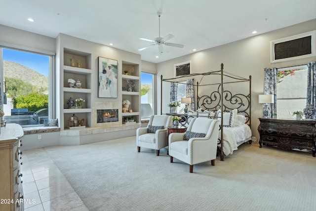 bedroom featuring a mountain view, light tile patterned floors, multiple windows, and ceiling fan