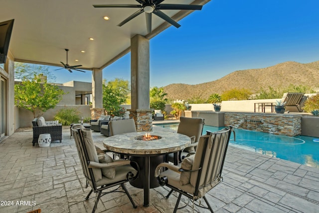 view of patio featuring a mountain view, exterior fireplace, and ceiling fan