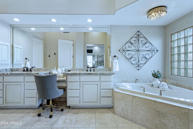 bathroom with tile patterned flooring, vanity, and a relaxing tiled tub