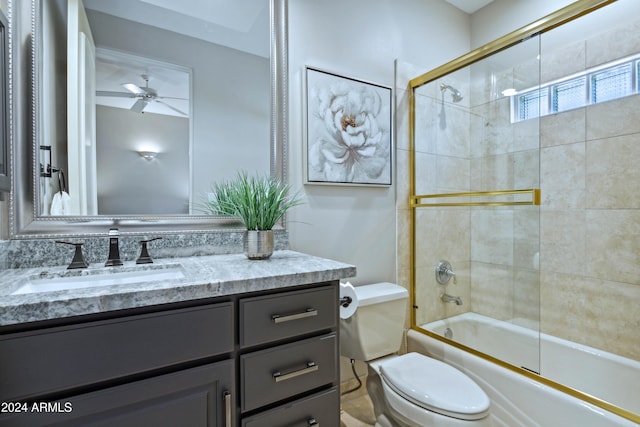 full bathroom with ceiling fan, vanity, enclosed tub / shower combo, and toilet