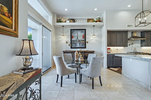 dining area with light tile patterned floors and an inviting chandelier