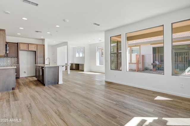 4053 Desert Moon Dr, Wickenburg, AZ 85390 - kitchen featuring light countertops, open floor plan, decorative backsplash, a kitchen island with sink, and recessed lighting