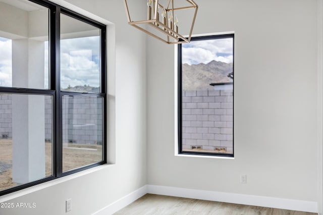26619 S 169th Pl, Queen Creek, AZ 85142 - spare room featuring a chandelier, baseboards, and wood finished floors