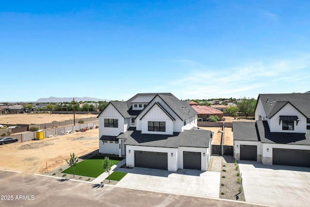 26619 S 169th Pl, Queen Creek, AZ 85142 - modern inspired farmhouse with board and batten siding, concrete driveway, fence, a garage, and a mountain view