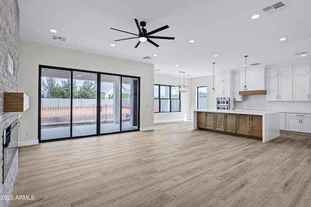 26619 S 169th Pl, Queen Creek, AZ 85142 - kitchen with a ceiling fan, a fireplace, light wood finished floors, open floor plan, and recessed lighting