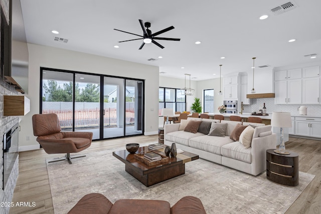 26619 S 169th Pl, Queen Creek, AZ 85142 - living room featuring a ceiling fan, recessed lighting, light wood finished floors, a glass covered fireplace, and baseboards