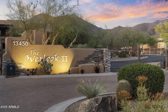 community / neighborhood sign with fence and a mountain view