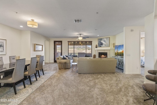 carpeted living area with visible vents, recessed lighting, ceiling fan, and a tile fireplace