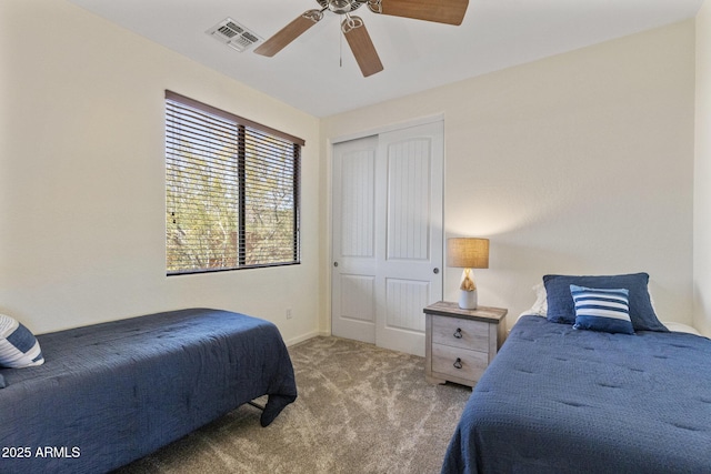 carpeted bedroom with a ceiling fan, baseboards, visible vents, and a closet